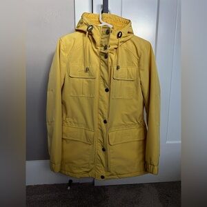 Bright yellow hooded and quilted jacket with drawstring